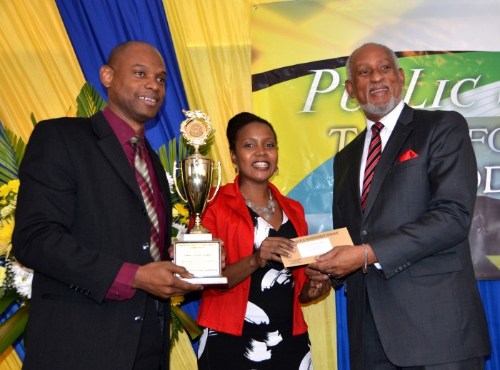 Cabinet Secretary, Ambassador, Hon. Douglas Saunders (right) presents the trophy and a $200,000 cheque to the Chief Executive Officer (CEO) of the Firearm Licensing Authority  (FLA), Dr. Kenrey Wedderburn (left) and the Director of Applications and Certification at the FLA, Miss Letine Allen, at the Public Sector Customer Service Competition at the Terra Nova All-Suites Hotel on Friday, October 9. The FLA was recognised as being the Most Improved Entity in the competition put on by the Cabinet Office. 