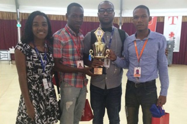 From Left) Titchfield High School Students Aliyah Patterson , Teshane Chambers along with Physics Teacher at the institution, Rammon Green and student, Damion McKenzie show off their trophy. The students were the winners of the 2016 Caribbean Youth Science Forum Competition held in Trinidad and Tobago from July 31 to August 7.