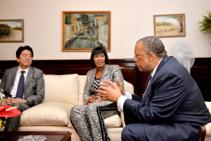 Prime Minister, the Most Hon. Portia Simpson Miller, and Prime Minister of Japan, His Excellency Mr. Shinzo Abe (left), listen to a point being made by Minister of Finance and Planning, Hon. Dr. Peter Phillips, just before the start of a dinner reception at Vale Royal on September 30, in honour of Prime Minister Abe.