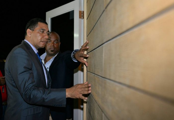 Prime Minister, the Most Hon. Andrew Holness (left), inspects the exterior of the ‘tiny house’ which was on display at the opening of the three-day Build Expo and Conference at the Montego Bay Convention Centre in St. James on June 9. At right, Conference Chairman, Dwight Crawford, highlights the features.