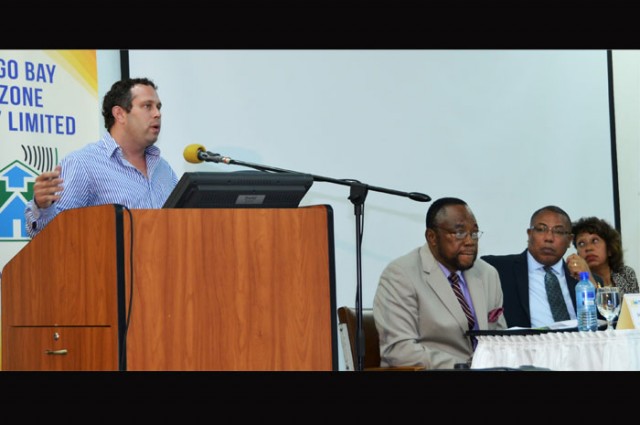 President of the Business Process Industry Association of Jamaica (BPIAJ), Yoni Epstein (at podium), addresses the Montego Bay Free zone Company forum under the theme: 'BPO - exploring opportunities within the sector', which was held  at the Montego Bay Community College recently, as part of the company's 30th anniversary celebration.
At the head table (from left) are: Moderator and Deputy Chairman of the Montego Bay Free zone Board, Shallman Scott; Minister of Industry, Investment and Commerce, Hon. Anthony Hylton, and Jamaica Promotions Corporation (JAMPRO) President,  Diane Edwards.
