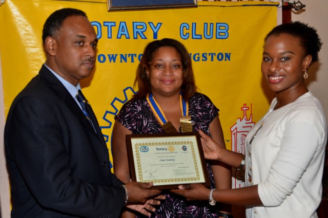 Managing Director of the Jamaica Social Investment Fund (JSIF), Mr. Omar Sweeney (left), accepts a certificate of appreciation from a member of the Rotary Club of Downtown Kingston, Ms. Kahmile Reid (right), following his presentation at a meeting of the Club on Wednesday, February 3, at the Hotel Four Seasons. President of the Club, Ms. Melanie Reece (centre), shares in the moment.