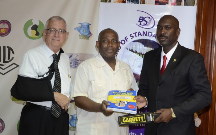 Minister of Education, Hon. Rev. Ronald Thwaites (left) and Director of Safety and Security in the Ministry, Sergeant Coolridge Minto (right), hand over a metal detector and a compilation of revised Safety and Security manuals to Principal of the Haile Selassie High School, Mr. Lorenzo Ellis, during a handing over ceremony at the Ministry’s head office on Tuesday, September 29. The Ministry will also be distributing 135 metal detectors to secondary schools this week.