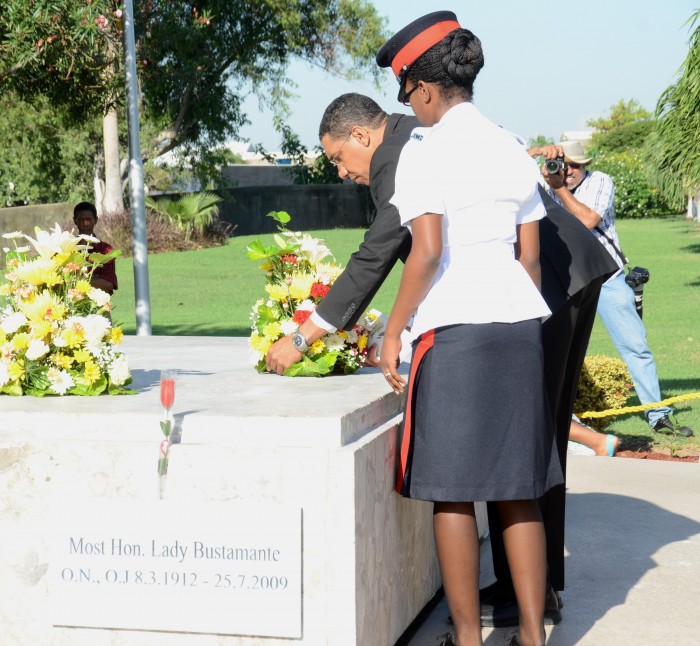 Leader of the Opposition, Andrew Holness (right), places a wreath at the shrine of National Hero, the Rt. Excellent Sir Alexander Bustamante, in honour of the 132nd anniversary of his birth, during a floral tribute at National Heroes Park, in Kingston, today (February 24). Observing is Constable Shaneika Murray-Bartley.