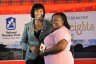 Prime Minister, the Most Hon. Portia Simpson Miller (left), presents Yanique Thompson with a certificate of possession to a housing lot in the Balaclava Heights development in St. Elizabeth, at the handing over ceremony held on Wednesday (December 9).