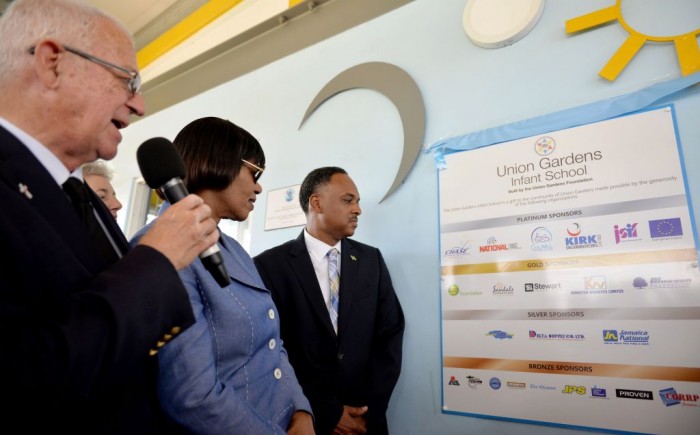 Prime Minister, the Most Hon. Portia Simpson Miller (centre), looks at a plaque detailing the sponsors of the state-of-the-art Union Gardens Infant School, at the official opening of the institution on Wednesday, January 13. Others (from left) are: Minister of Education, Hon. Rev. Ronald Thwaites; and Managing Director of the Jamaica Social Investment Fund (JSIF), Mr. Omar Sweeney. The school, located in South West St. Andrew was constructed last year through the collaboration of several public and private partners.