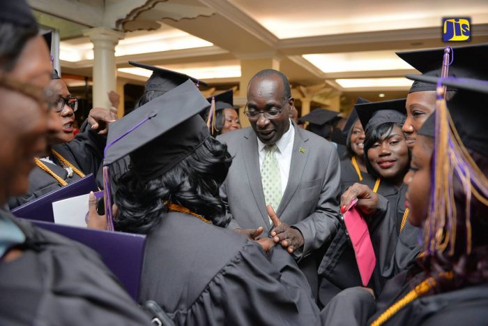 Education, Youth and Information Minister, Senator the Hon. Ruel Reid (centre), conversing with graduates of Western Carolina University following the institution's fall commencement, which was held at the Knutsford Court Hotel in New Kingston on Friday, October 21.