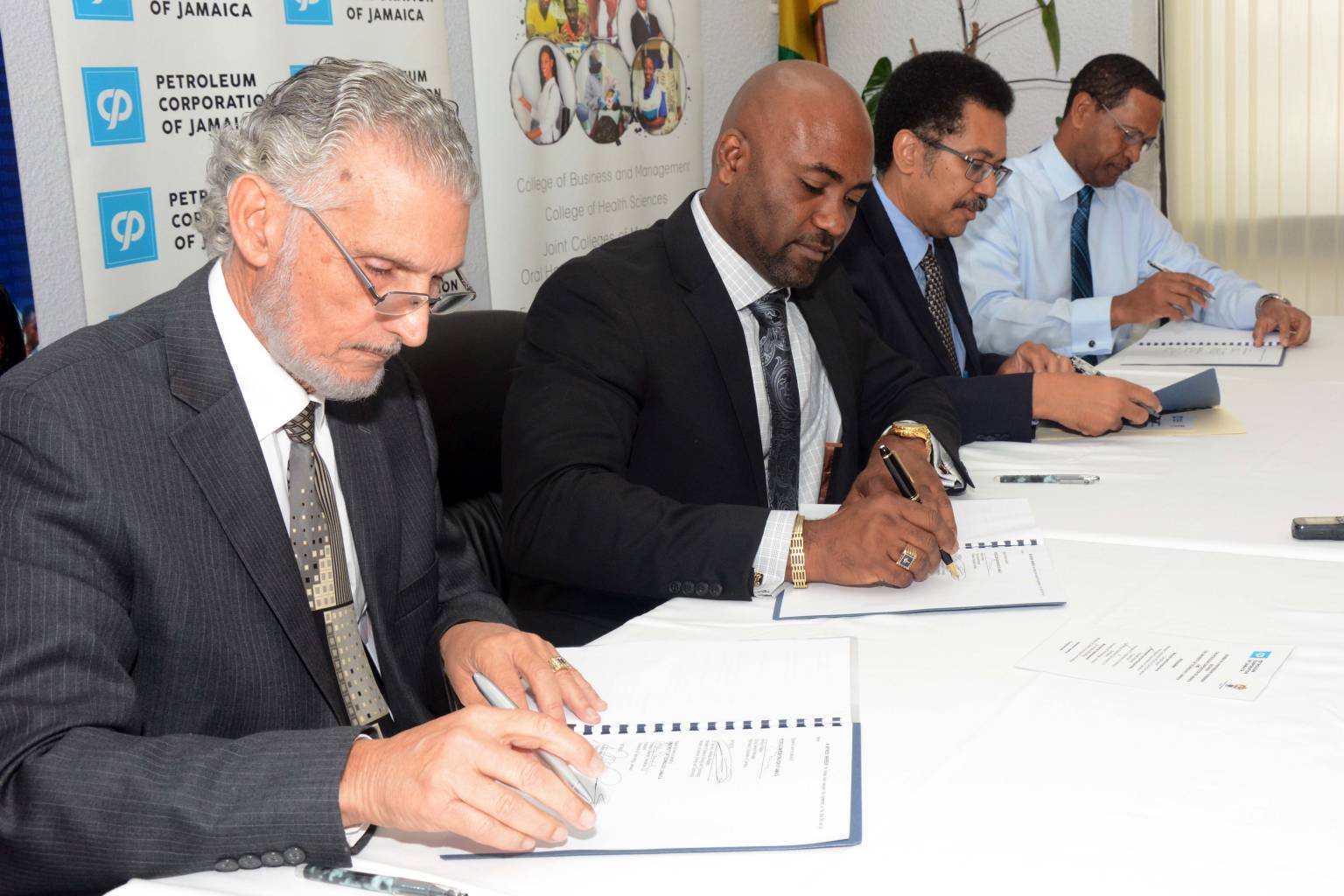 It was serious business as (from left) Mr. Russell Hadeed, Chairman, Petroleum Corporation of Jamaica (PCJ), Dr. Andrew Wheatley, Minister of Science, Energy and Technology, Professor Stephen Vasciannie, President, University of Technology, Jamaica and Mr. Winston Watson, Group General Manager, PCJ signed a partnership agreement to establish the PCJ Renewable Energy Scholarship and a grant which will provide funding for research projects to be undertaken by students at UTech’s School of Engineering.  Under the agreement, which was signed today, (Wednesday March 15) at the PCJ Resource Centre in New Kingston, the PCJ will provide up to $5 million to finance the research grant and the Scholarship. 