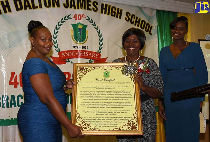 Teacher of the Edith Dalton James High School, Sharon Brown (left), presents retiree and former Head of the Electrical Technology Department at the institution, Earle Bisasor, with his citation at the school’s 40th anniversary retirement function at The Knutsford Court Hotel in New Kingston on May 31.

