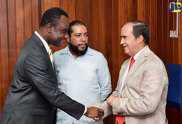 Permanent Secretary in the Ministry of Education, Youth and Information, Dean-Roy Bernard (left), greets Mexico’s Ambassador to Jamaica, His Excellency Juan José Gonzalez Mijares (right), at Thursday’s (July 19) launch of the ‘Project for Capacity Development in Digital Preservation for Records and Information Professionals’, at the Ministry in Kingston.  At centre is Director for Information Technology at the General National Archives of Mexico,  Erick Cardoso Espinosa. 