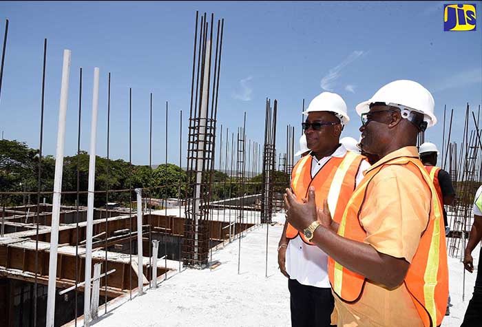 Local Government and Community Development Minister, Hon. Desmond Thomas (right), converses with Portmore’s Mayor, Leon McKenzie, while on tour of the new Portmore Municipal Corporation building in St. Catherine, which is currently under construction. 
