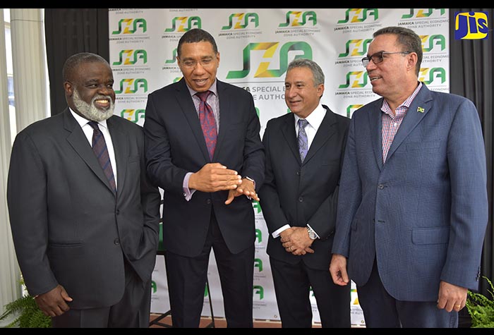 Prime Minister, the Most Hon. Andrew Holness (second left), shares a laugh with (from left): Jamaica Special Economic Zone Authority (JSEZA) Chief Executive Officer, Dr. Eric Deans and Chairman, Metry Seaga; and Minister without Portfolio in the Ministry of Economic Growth and Job Creation, Hon. Daryl Vaz, during Wednesday's (July 11) official opening of the JSEZA, on Waterloo Road in St. Andrew. Mr. Holness was the keynote speaker.