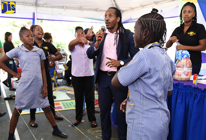 State Minister for Culture, Gender, Entertainment and Sport, Hon. Alando Terrelonge (second right), highlights the benefits of play through games, such as ‘Chinese skip’, during a forum focusing on the importance of play for children, at the Maxfield Park Children’s Home on Tuesday (November 6). Engaging in the game of ‘Chinese skip’ are students from the Seaward Primary and Junior High School. They are (in the foreground, from left)  Shadae Salmon, and Latanya Graham.   At right is media personality and host of the forum, Emprezz Golding.