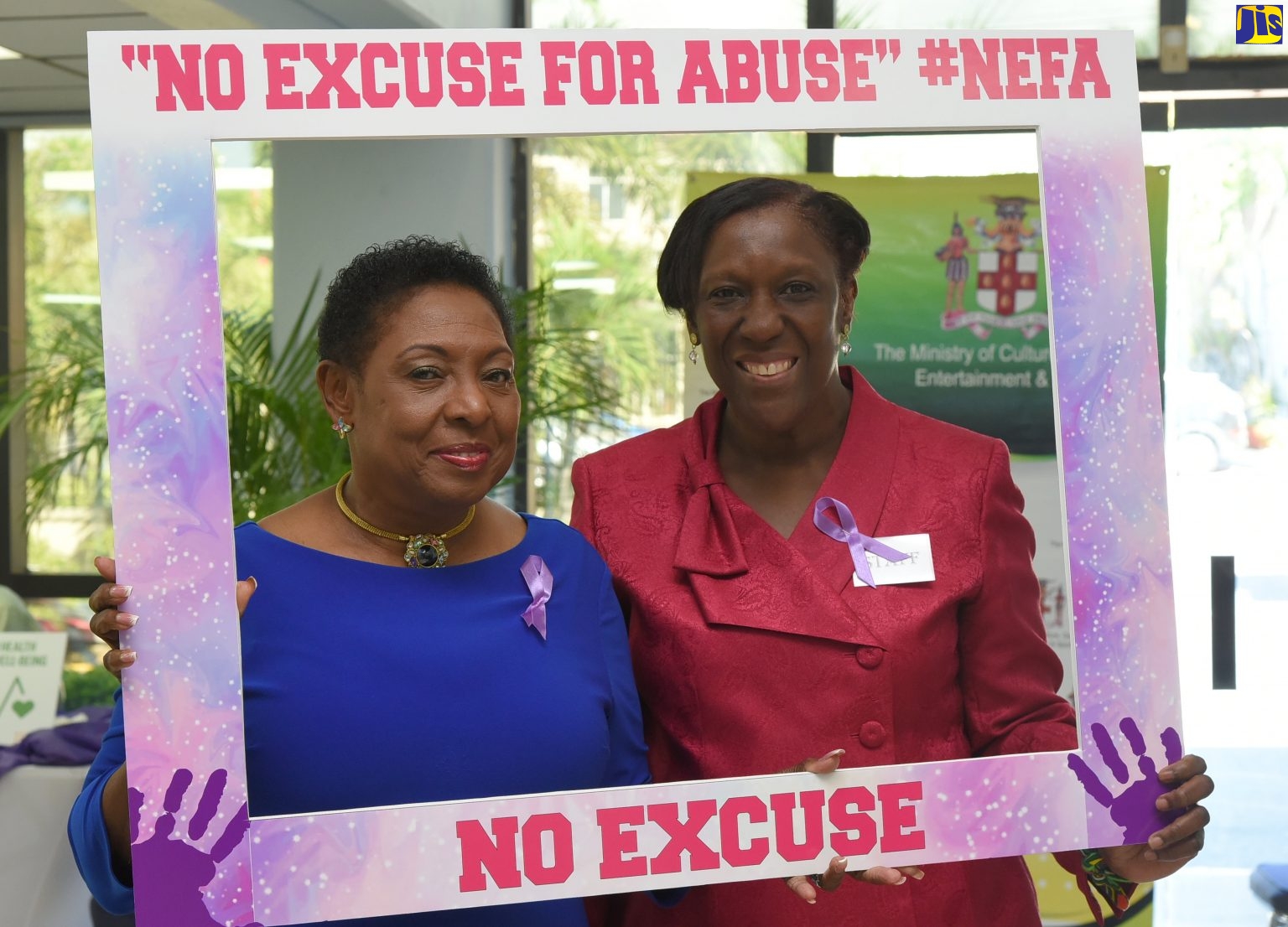 Minister of Culture, Gender, Entertainment and Sport, Hon. Olivia Grange (left); and Acting Senior Director for Gender Affairs in the Ministry, Sharon Coburn Robinson, pose with a social media frame for the newly launched No Excuse for Abuse (#NEFA) public education campaign. Miss Grange officially launched the campaign during a public forum, entitled ‘Big Ooman and Big Man Chat: Addressing Intimate Partner Violence (IPV)’, at the Courtleigh Auditorium in New Kingston on Tuesday (December 4).