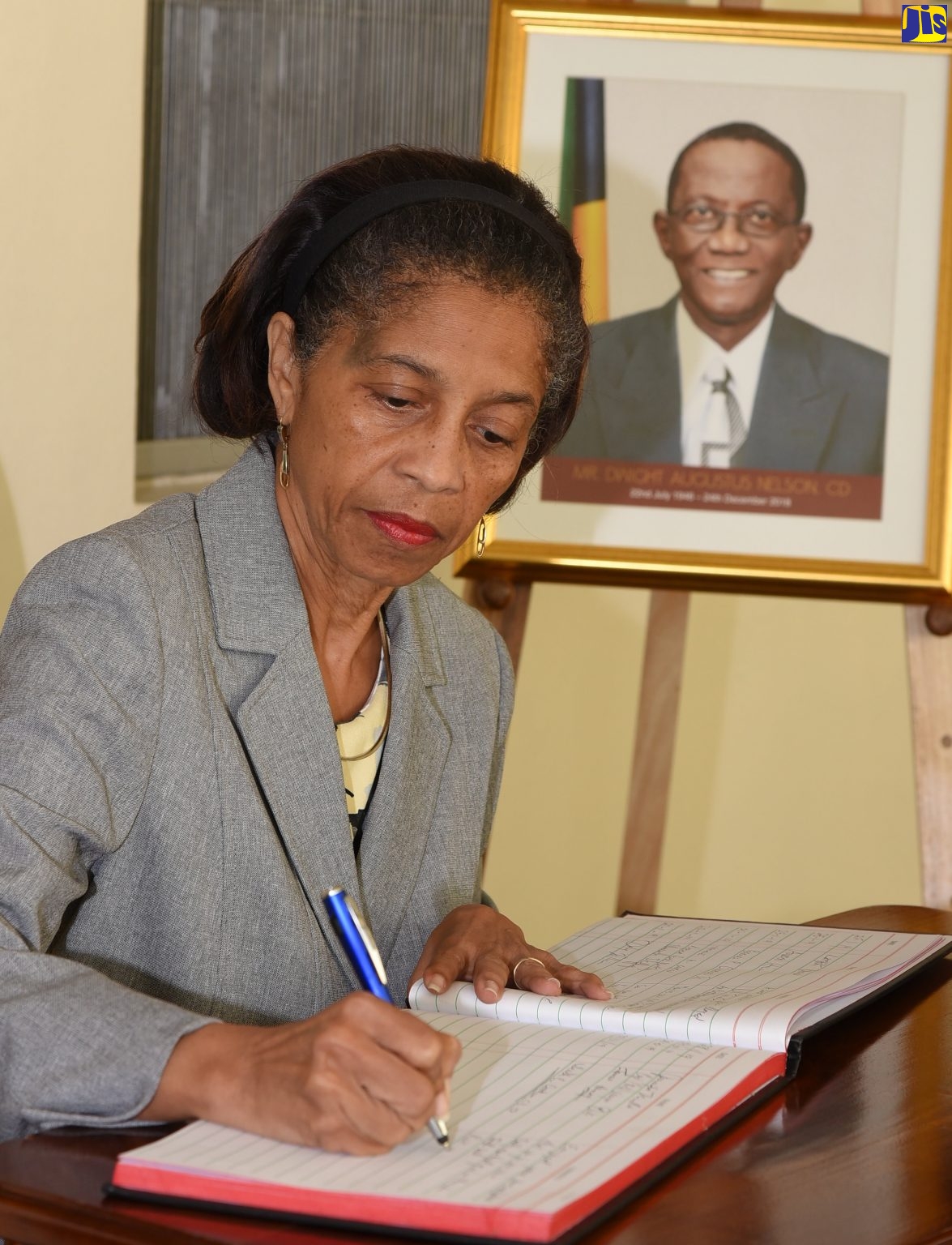 Clerk to the Houses of Parliament, Heather Cooke, signs the condolence book opened at Gordon House for former Government Minister, the late Dwight Nelson, who died  at the age of 72 on December 24, 2018. The official funeral for Mr. Nelson will be held at the Holy Trinity Cathedral, North Street, Kingston, on January 31, beginning at 10:00 a.m. Interment will follow at the Dovecot Memorial Park.  Mr. Nelson, a trade unionist, served as a Senator, Minister without Portfolio in the Ministry of Finance and the Public Service and Minister of National Security.