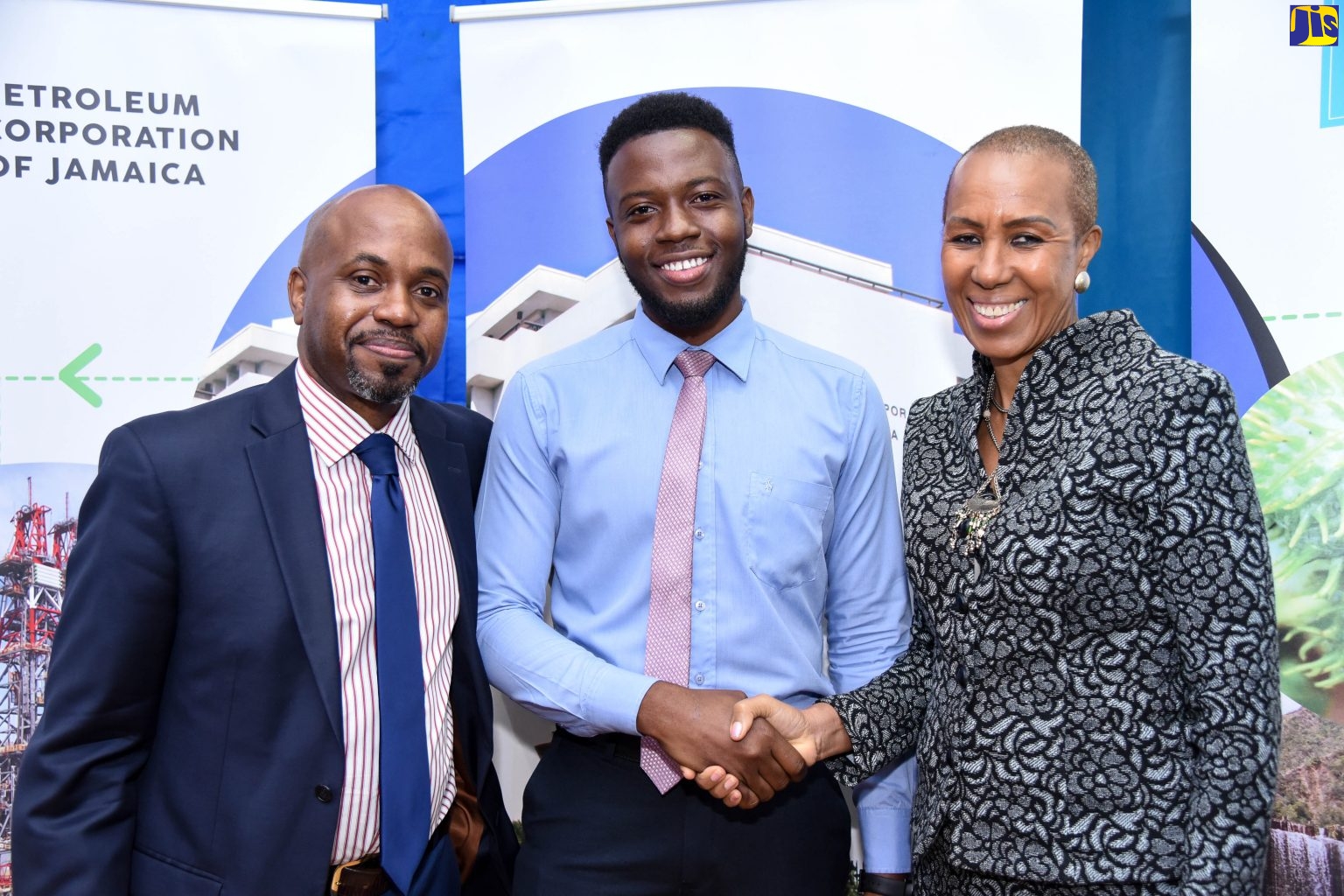 Science, Energy and Technology Minister, Hon. Fayval Williams (right), greets the 2018/19 Petroleum Corporation of Jamaica (PCJ) Renewable Energy Scholarship recipient, Arlando Dunkley, during a presentation ceremony at the PCJ Auditorium in New Kingston on March 27. Looking on is PCJ Acting Group General Manager, Brian Richardson