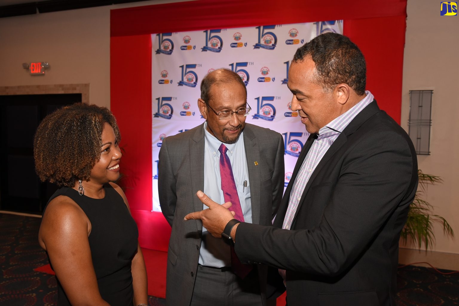 Minister of Health, Dr. the Hon. Christopher Tufton (right), is in light discussion with Deputy Chairman of the National Health Fund (NHF), Dr. Dana Morris Dixon (left); and President of the Private Sector Organisation of Jamaica (PSOJ), Howard Mitchell, at the NHF's 15th anniversary awards banquet held recently, at The Jamaica Pegasus hotel, New Kingston.