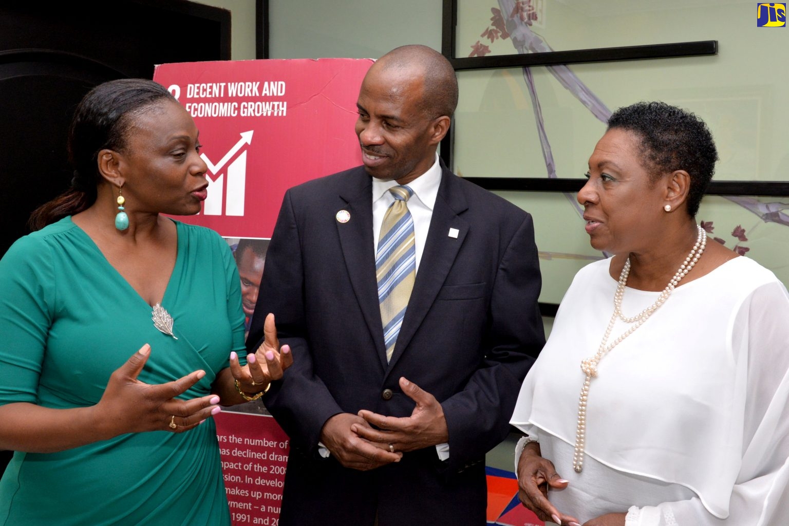 Minister of Culture, Gender, Entertainment and Sport, Hon. Olivia Grange (right) and President, Jamaica Chamber of Commerce (JCC), Lloyd Distant (centre), listen to United Nations Development Programme  (UNDP) Resident Representative, Dr. Elsie Laurence-Chounoune, at the  International Women’s Day Breakfast on March 8, at The Courtleigh Hotel and Suites in New Kingston.  