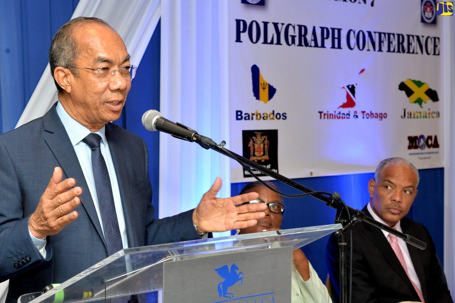 Minister of National Security, Hon. Dr. Horace Chang, addressing the Canadian Association of Police Polygraphists Region 7 Conference at The Jamaica Pegasus hotel in New Kingston on May 27. Listening are Region Director, Marchan Gittens; and Director General of  the Major Organised Crime and Anti-Corruption Agency, Col. Desmond Edwards. 
