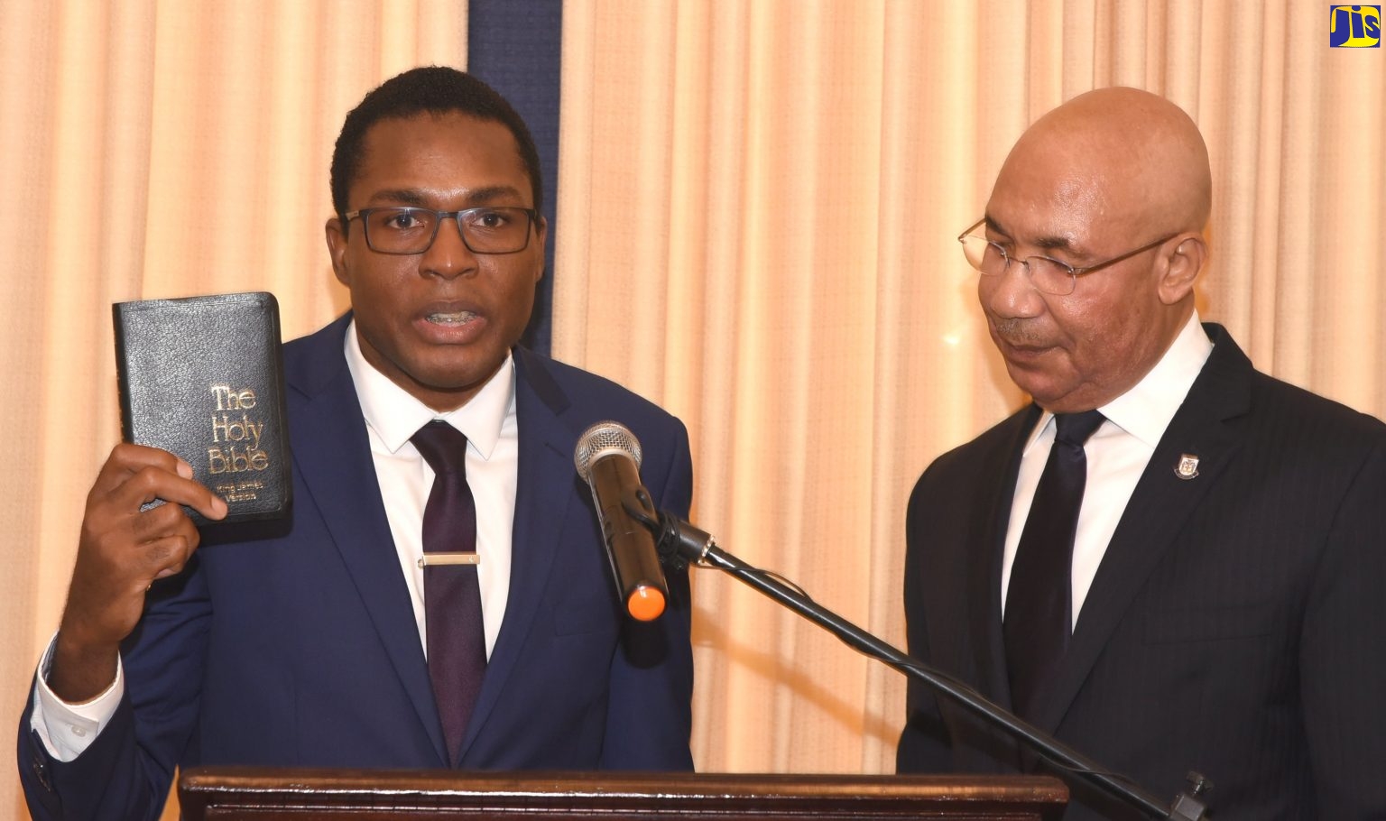 Governor General, His Excellency The Most Hon. Sir Patrick Allen (right) looks on while newly appointed Government Senator and Parliamentary Secretary, Robert Nesta Morgan, takes the Oath of Office during a swearing-in ceremony held at King’s House on May 9.