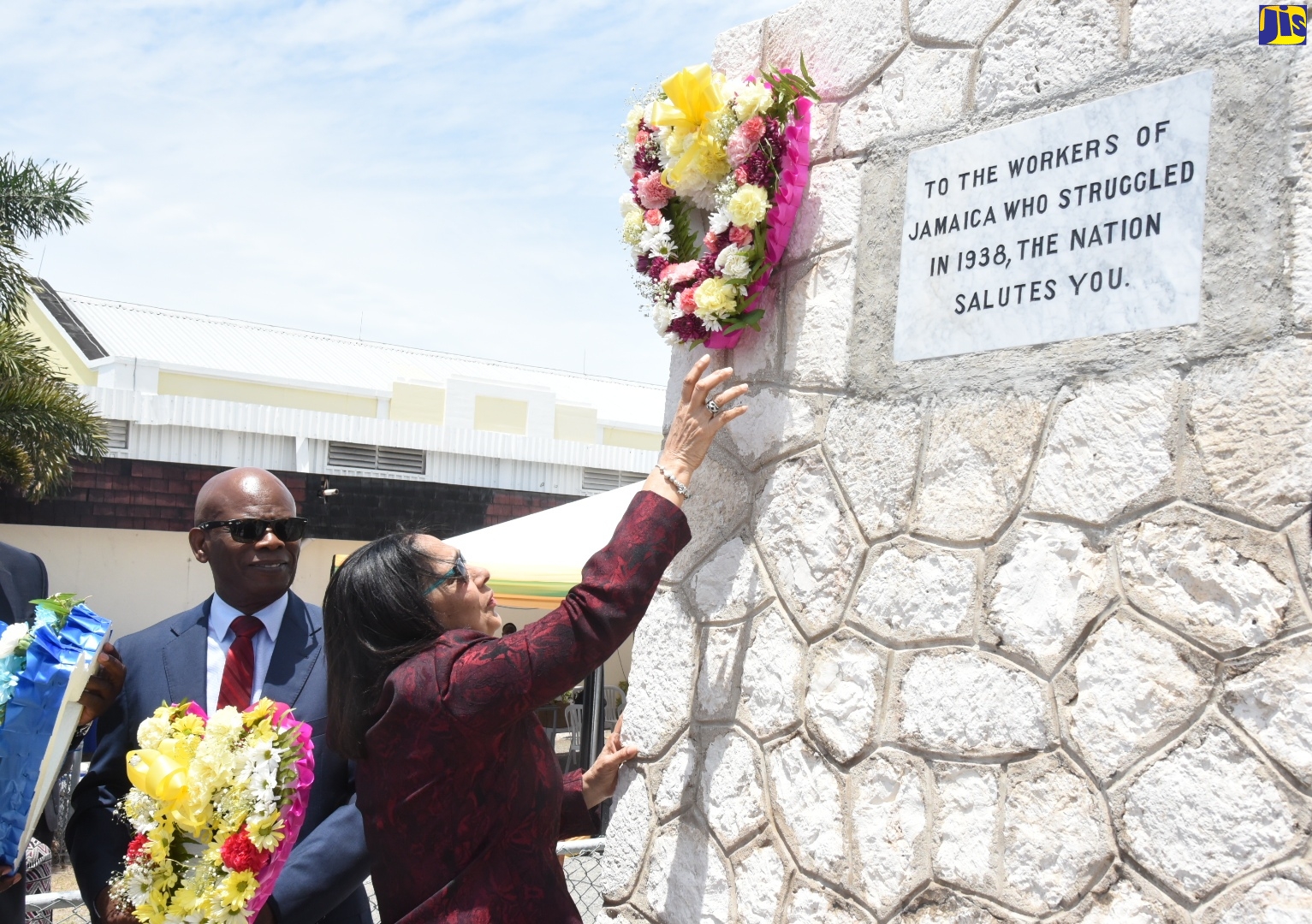 Labour and Social Security Minister, Hon. Shahine Robinson (right), hangs a wreath on the Aggie Bernard Workers’ Monument, in downtown Kingston, during the National Workers’ Week/Labour Day Wreath-laying ceremony on Tuesday (May 21).  At left is Custos of Kingston and Deputy Governor-General, Hon. Steadman Fuller. The ceremony is held in tribute to Jamaican workers who participated in the 1938 Labour Riots, which led to improved conditions for today’s workers. Workers’ Week runs from May 19 to 23 and is being observed under the theme ‘Yes to Decent Work, No to Child Labour’. Thursday, May 23 is celebrated as Labour Day.