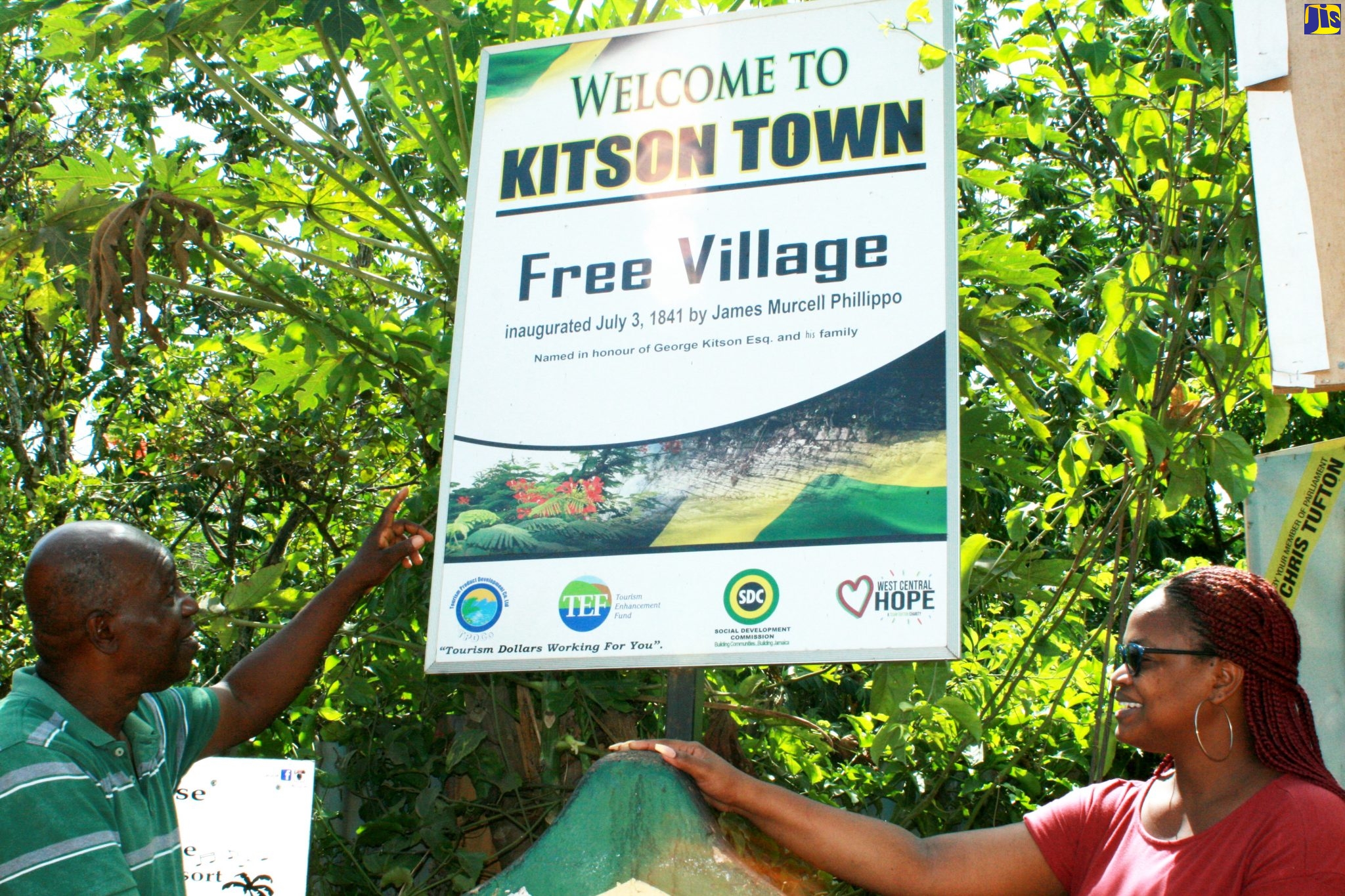 President of the Kitson Town Community Development Committee (CDC), Devon Thompson (left), and tour guide, Caryleon Riley, point to the sign highlighting Kitson Town’s significance as a free village.