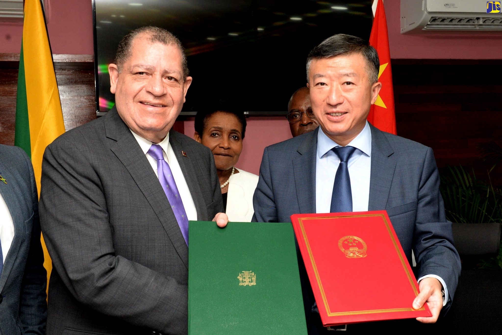 Minister of Industry, Commerce, Agriculture and Fisheries, Hon. Audley Shaw (left);  and Ambassador of the People’s Republic of China, His Excellency Tian Qi, exchange copies of the signed protocol governing the export of frozen lobster to China, at the Ministry’s Hope Gardens offices in St. Andrew on September 19.
