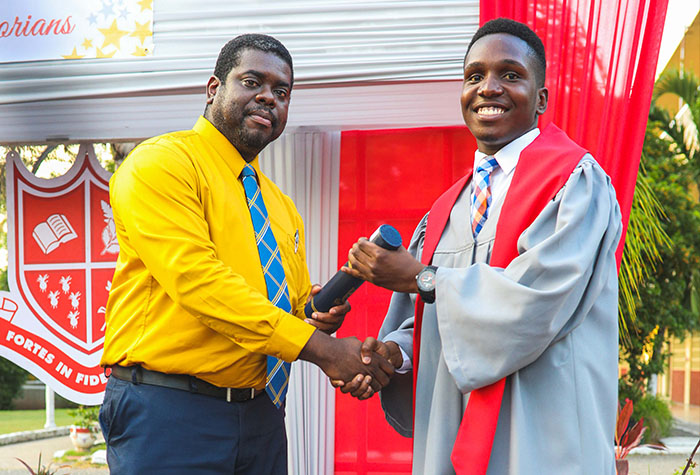 Recipient of the Jamaica Public Service (JPS) and Partners Co-operative Credit Union Limited 2019 Albert Morris Scholarship, Neikoy Redwood (right), accepts his school-leaving certificate from Vice Principal, Campion College, Lavare Henry, during the school’s 2019 graduation exercise in June. 
