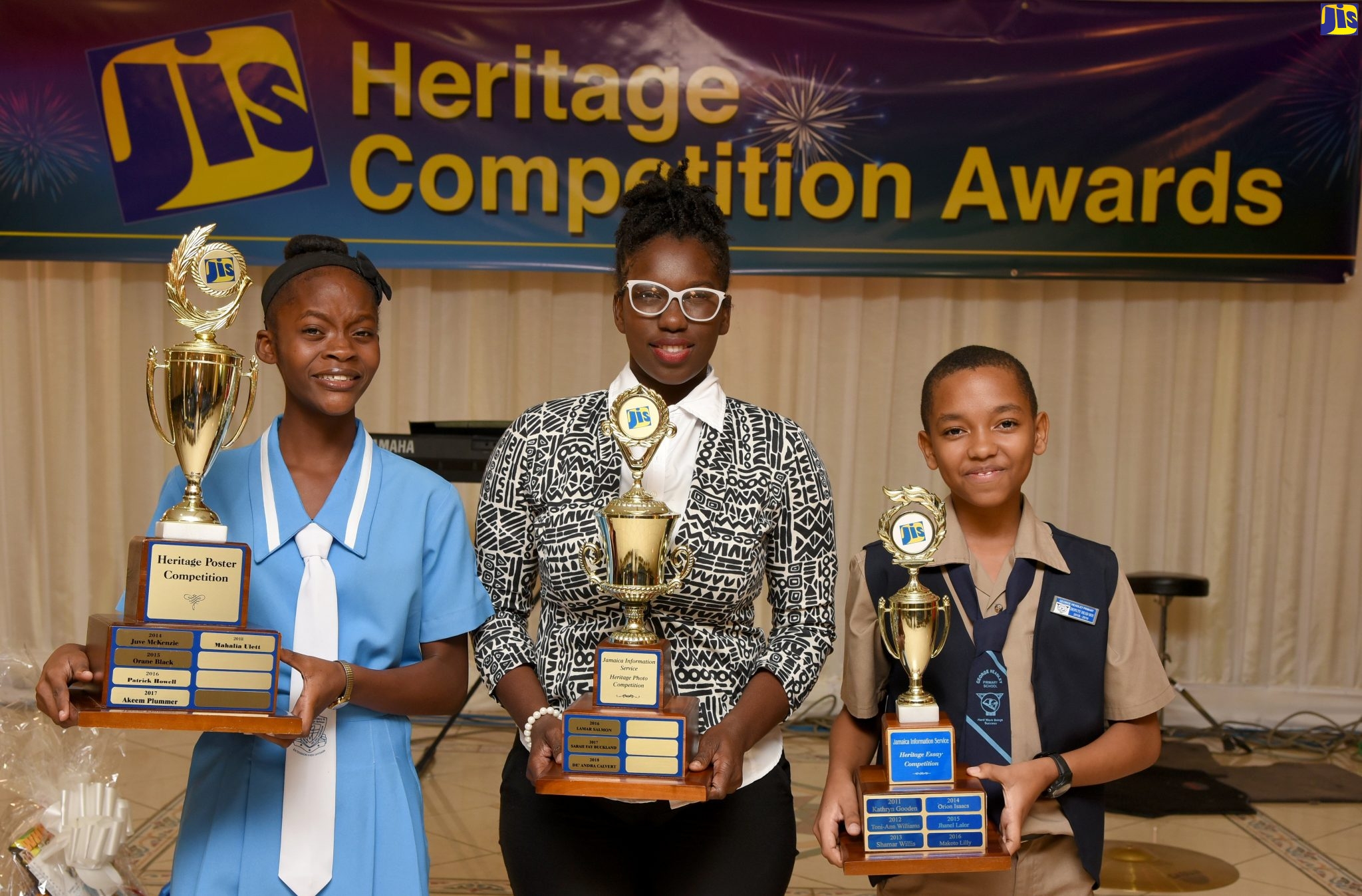 Winners of the Jamaica Information Service (JIS) 2018 Heritage Competition show off their trophies at the awards ceremony held at the Mona Visitors’ Lodge, St. Andrew. From (left) are Mahalia Ulett of Ardenne Preparatory and Extension High, who won in the poster category;  De’andra Calvert of the University of Technology (UTech), who took top honours in the photography component; and George Headley Primary School student, Gianni Willie, who placed first in the essay category.