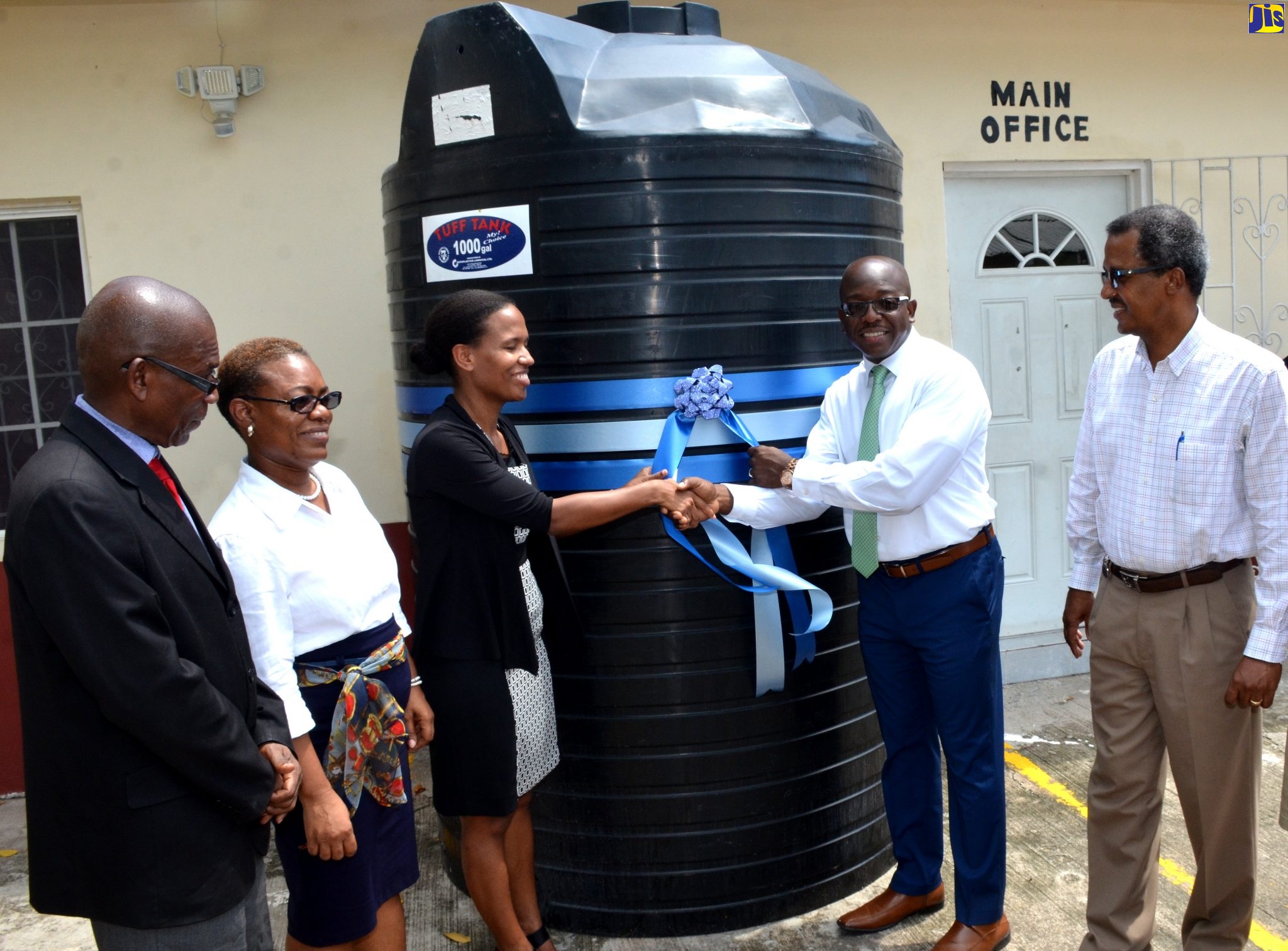 Minister without Portfolio in the Ministry of Economic Growth and Job Creation, Senator the Hon. Pearnel Charles Jr. (right) hands over 1,000-gallon water tank to Executive Director, Caribbean Christian Centre for the Deaf (CCCD), in Kingston, Tashi Widmer (third left), today (September 24). Sharing the moment (from left) are Principal and Campus Manager, CCCD, Earl Daley; Employee Development Officer, CCCD, Marcia Anderson; and Vice President of Divisional Operations (Eastern), National Water Commission (NWC), Michael Dunn.