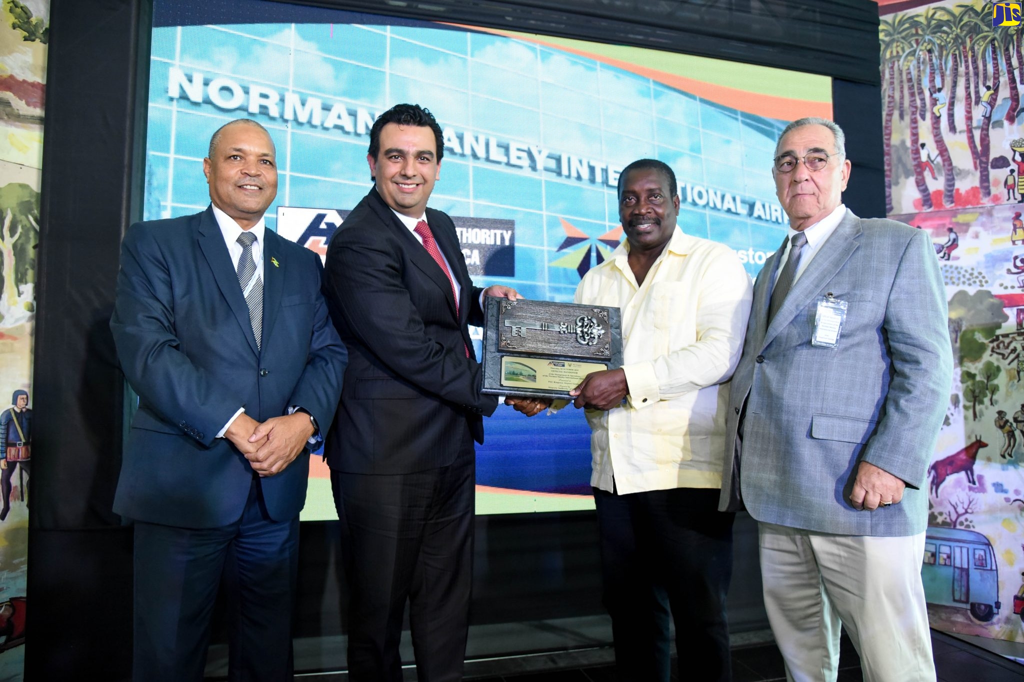 Minister of Transport of Mining, Hon. Robert Montague (2nd right), symbolically hands over the keys to the Norman Manley International Airport (NMIA) to Board Chairman of PAC Kingston Airport Limited (PACKAL) and Chief Executive Officer (CEO) of Grupo Aeroportuario del Pacifico (GAP),Raul Revuelta (2nd left), at the airport in Kingston on Wednesday (October 16). Sharing in the moment are CEO of the Airports Authority of Jamaica (AAJ), Audley Deidrick (left), and AAJ Chairman,  William Shagoury.
