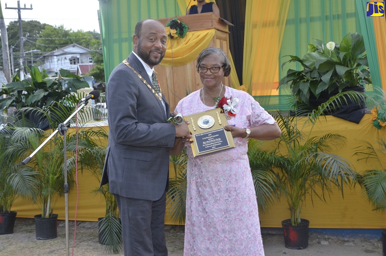 Mayor of St. Ann’s Bay, Councillor Michael Belnavis (left), presents an award to Buel Gloria Clarke for outstanding service in the field of Education during the St. Ann Municipal Corporation Civic Affairs and Community Relations Committee’s National Heroes Day Civic Ceremony, at Lawrence Park, St. Ann’s Bay, on Monday (October 21).