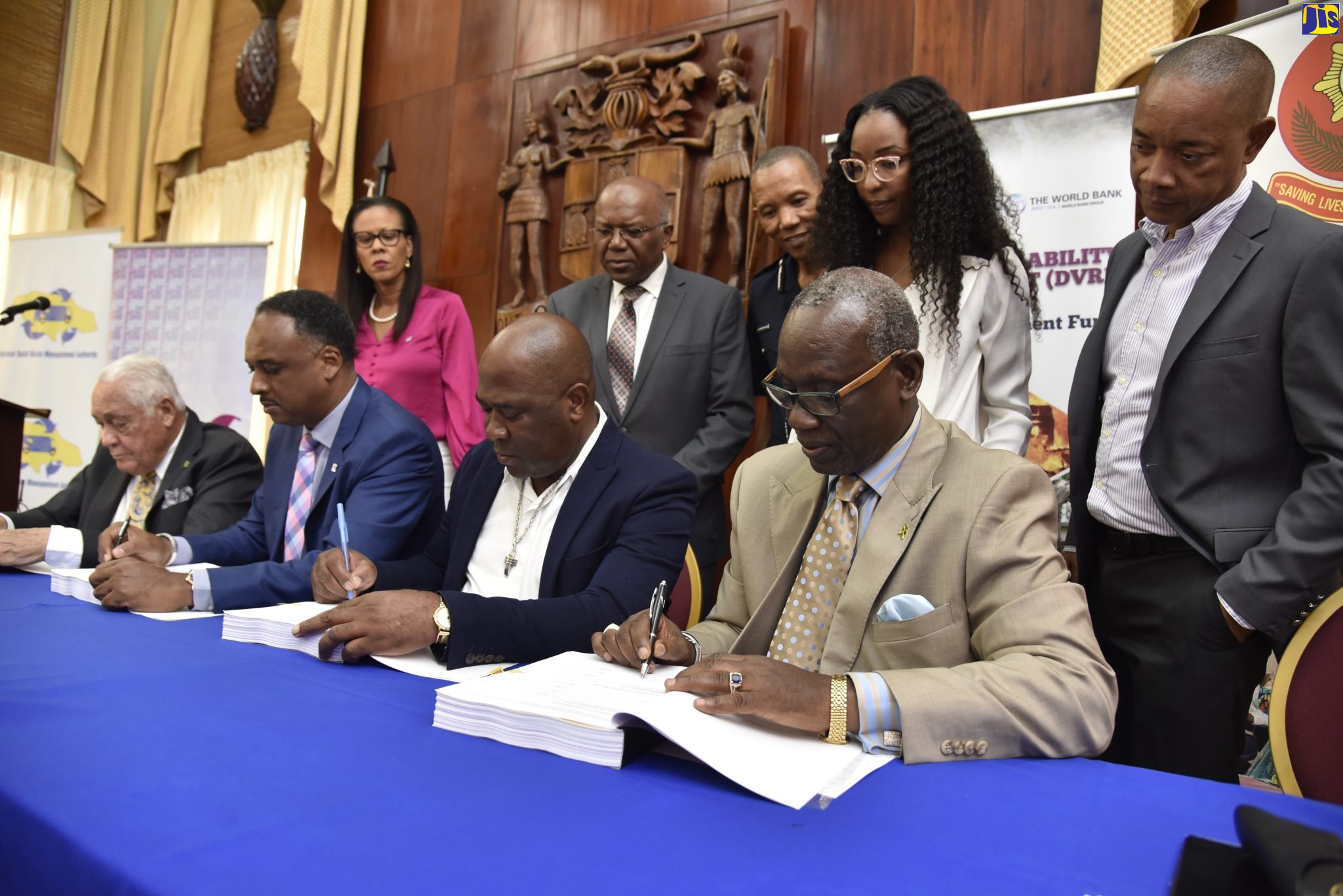 Minister of Local Government and Community Development, Hon. Desmond McKenzie (seated, right), and Minister without Portfolio in the Office of the Prime Minister (OPM), Hon. Mike Henry (second left), sign a $217-million contract for the construction of a state-of-the-art fire station, in Port Maria, St. Mary, at the OPM, on October 22. Others participating in the ceremony are (from left): Managing Director of the Jamaica Social Investment Fund (JSIF), Omar Sweeney; and Head of Marshall Construction Company Limited, Alphonso Reynolds. Observing (from left, standing) are JSIF Project Manager, Stacey-Anne Preston; Member of Parliament for Central St. Mary, Dr. Morais Guy; Commissioner of the Jamaica Fire Brigade, Stewart Beckford; Procurement Officer at JSIF, Stacy Stupart, and Chairman of the National Solid Waste Management Authority (NSWMA), Dennis Chung.