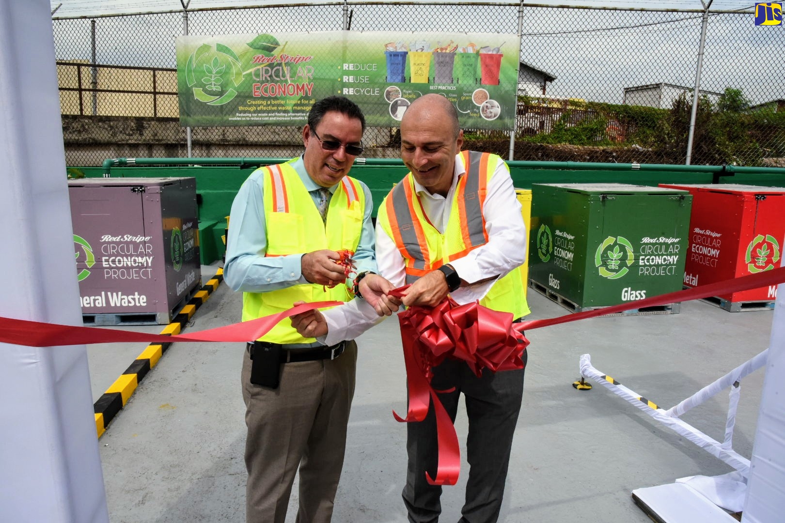Minister without Portfolio in the Ministry of Economic Growth and Job Creation, Hon. Daryl Vaz (left), cuts the ribbon to unveil Red Stripe’s redesigned area for waste storage. This followed the official launch of the ‘Red Stripe Circular Economy Project’, at the company’s Spanish Town Road location in St. Andrew, on Tuesday (October 22). The Minister is assisted by the brewery’s Managing Director, Luis Prata. The project seeks to divert waste streams of wood, paper, plastics and metal to productive enterprise, thereby reducing the company’s waste to landfill output to zero.