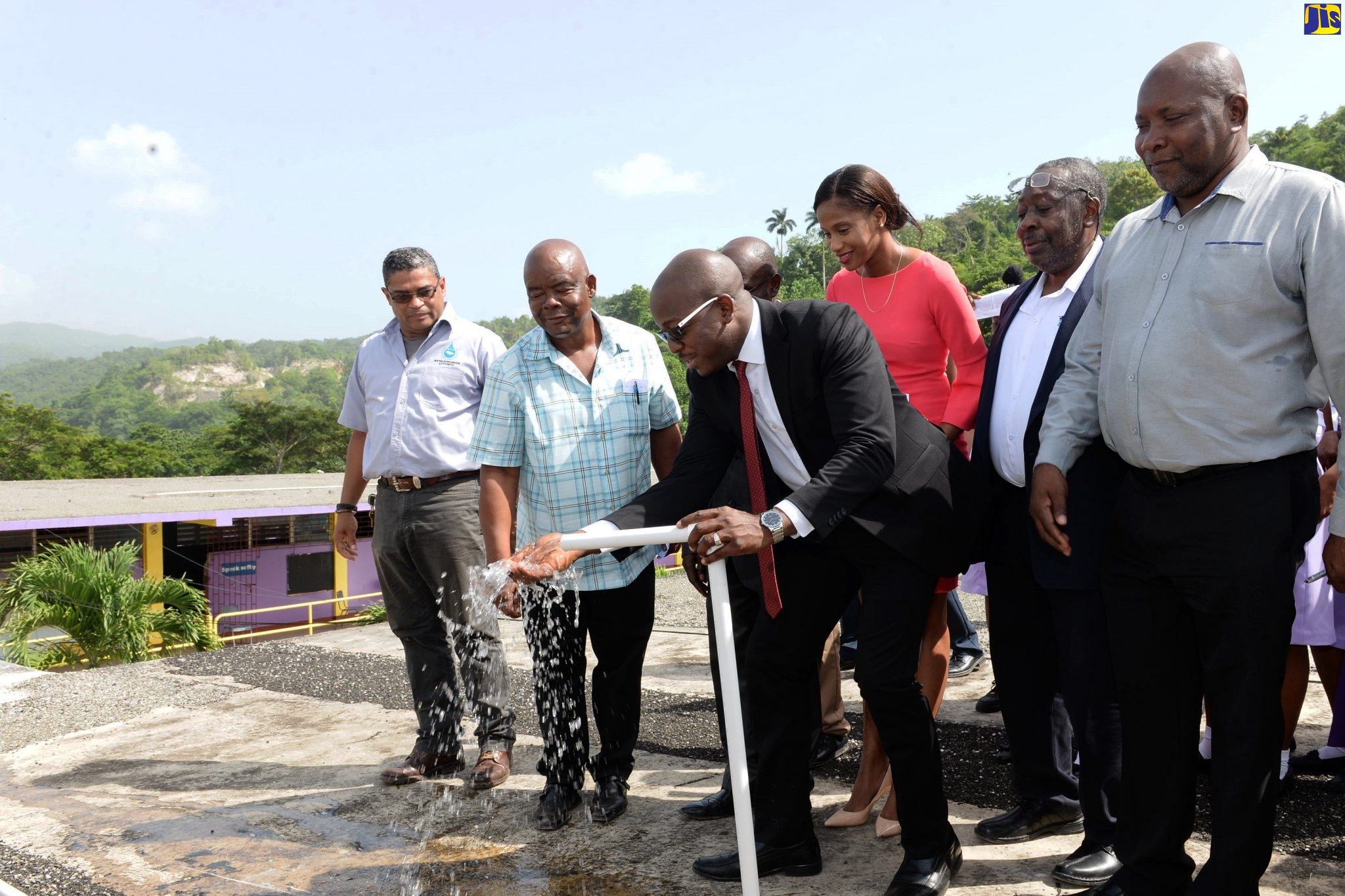 Minister without Portfolio in the Ministry of Economic Growth and Job Creation, Senator the Hon. Pearnel Charles Jr., (foreground), commissions into service a $7-million rainwater harvesting system at the St. Catherine-based Enid Bennett High School on Tuesday (October 8). The system was installed by the Rural Water Supply Limited (RWSL). Looking on (from left) are Managing Director of the Water Resources Authority (WRA), Peter Clarke; teacher at the school, Kenneth McNeil; RWSL board member Rhoda Crawford; Managing Director of the RWSL, Audley Thompson; and Regional Manager at the National Water Commission (NWC), Garwaine Johnson.