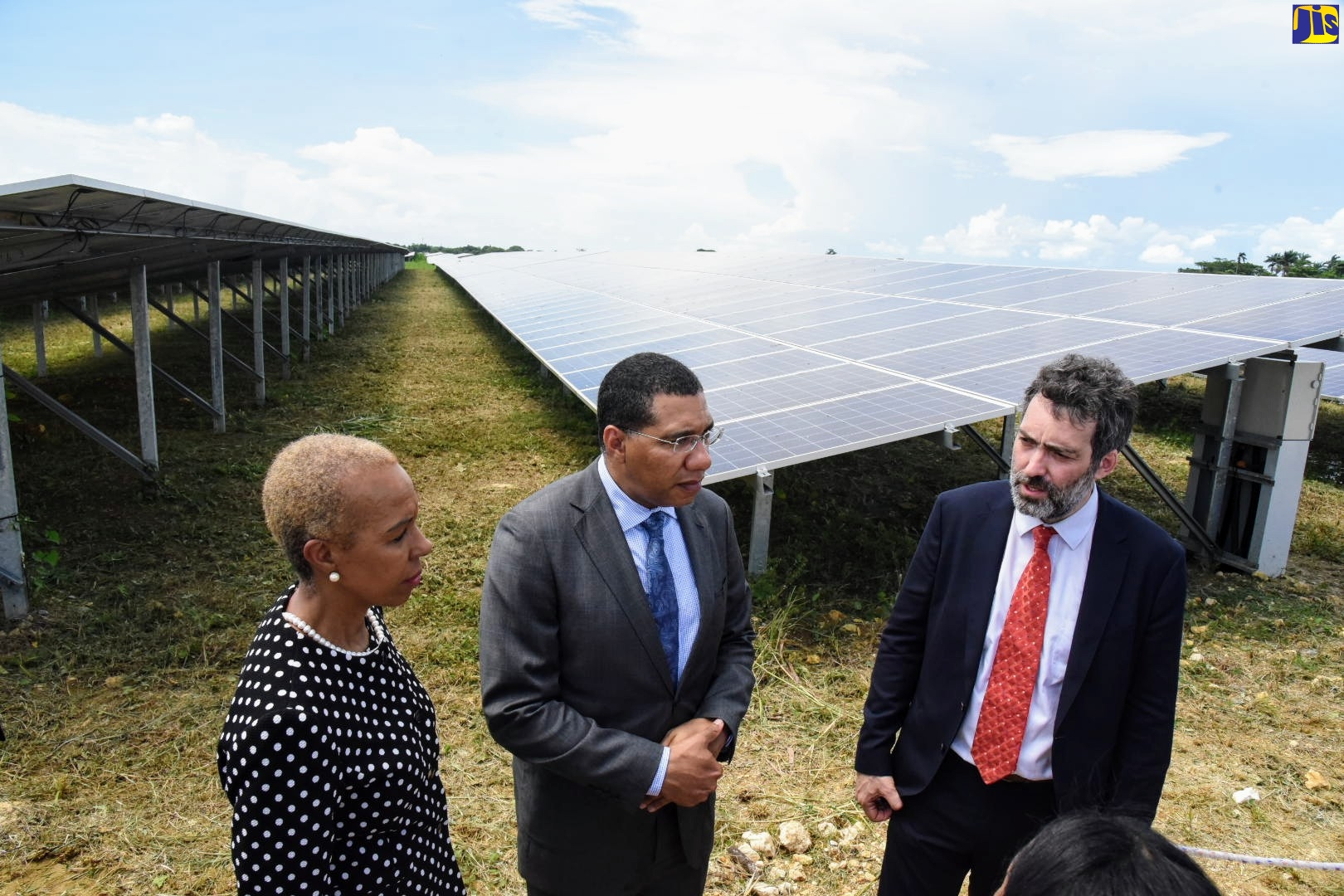 Prime Minister, the Most Hon. Andrew Holness (centre), listens to Deputy Chief Executive Officer (CEO) of Paradise Park Solar Farm in Westmoreland, Romain Desrousseaux, during a tour on October 2.  At left is Minister of Science, Energy and Technology, Hon. Fayval Williams.