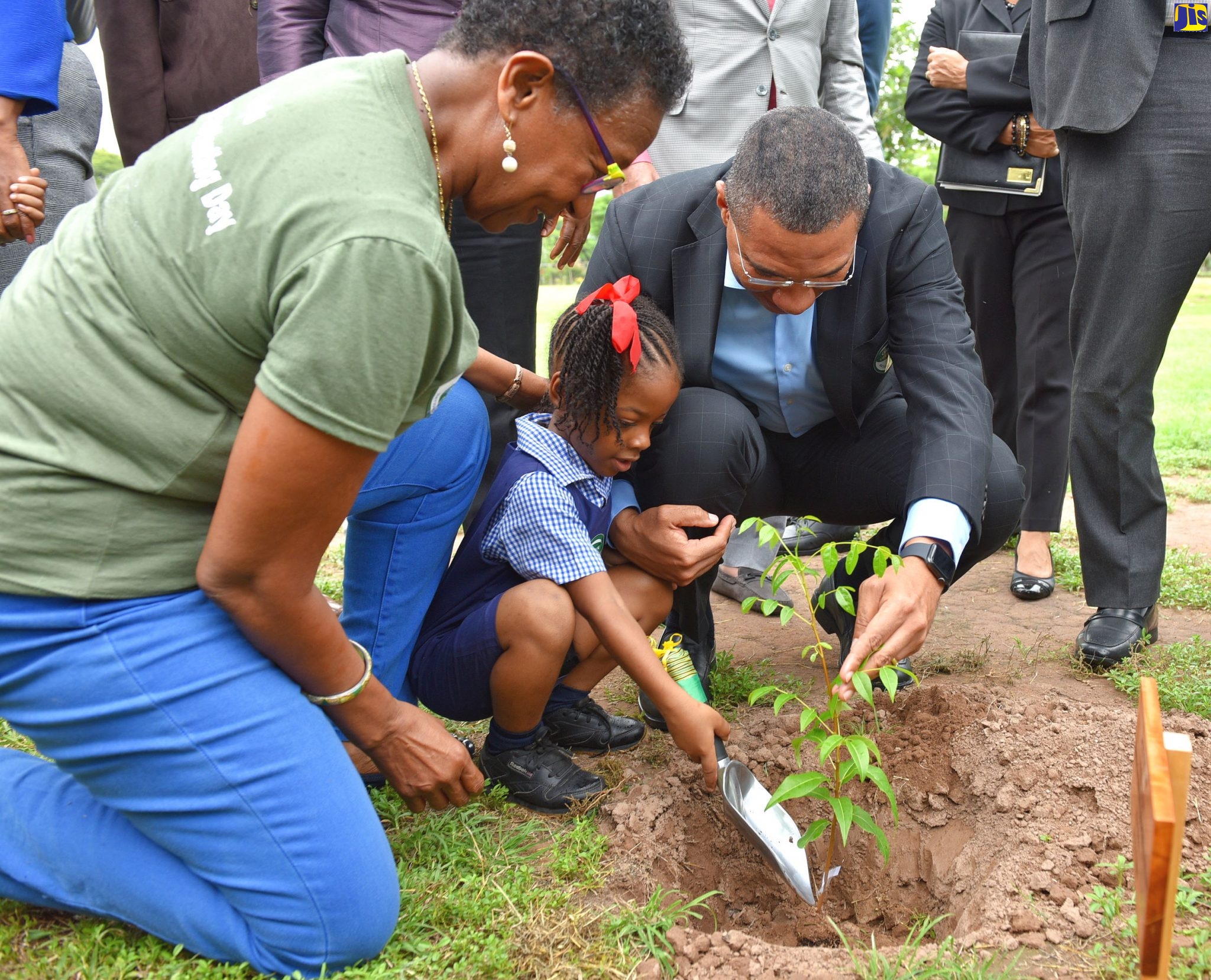 Prime Minister, the Most Hon. Andrew Holness (right), is assisted by student at the Jamaica House Basic School in St. Andrew, Zaire Quest (centre), to plant a Jamaican Mahogany tree, at the launch of the National Tree Planting Programme  on Friday (October 4) at Jamaica House.  The initiative will result in the planting of three million trees over the next three years. Looking on is Chief Executive Officer at the Forestry Department and Conservator of Forests, Marilyn Headley.