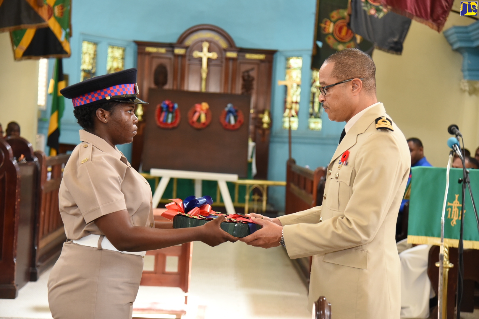 Jamaica Defence Force Private, Tanya Wilson (left) presents a wreath to Captain David Chin Fong for laying in remembrance of fallen soldiers. This was during the Memorial Day service held at Garrison Church of the Ascension, Up Park Camp, on November 10. Jamaica honoured the memory of the fallen servicemen and servicewomen of World Wars I and II on Remembrance Day.
