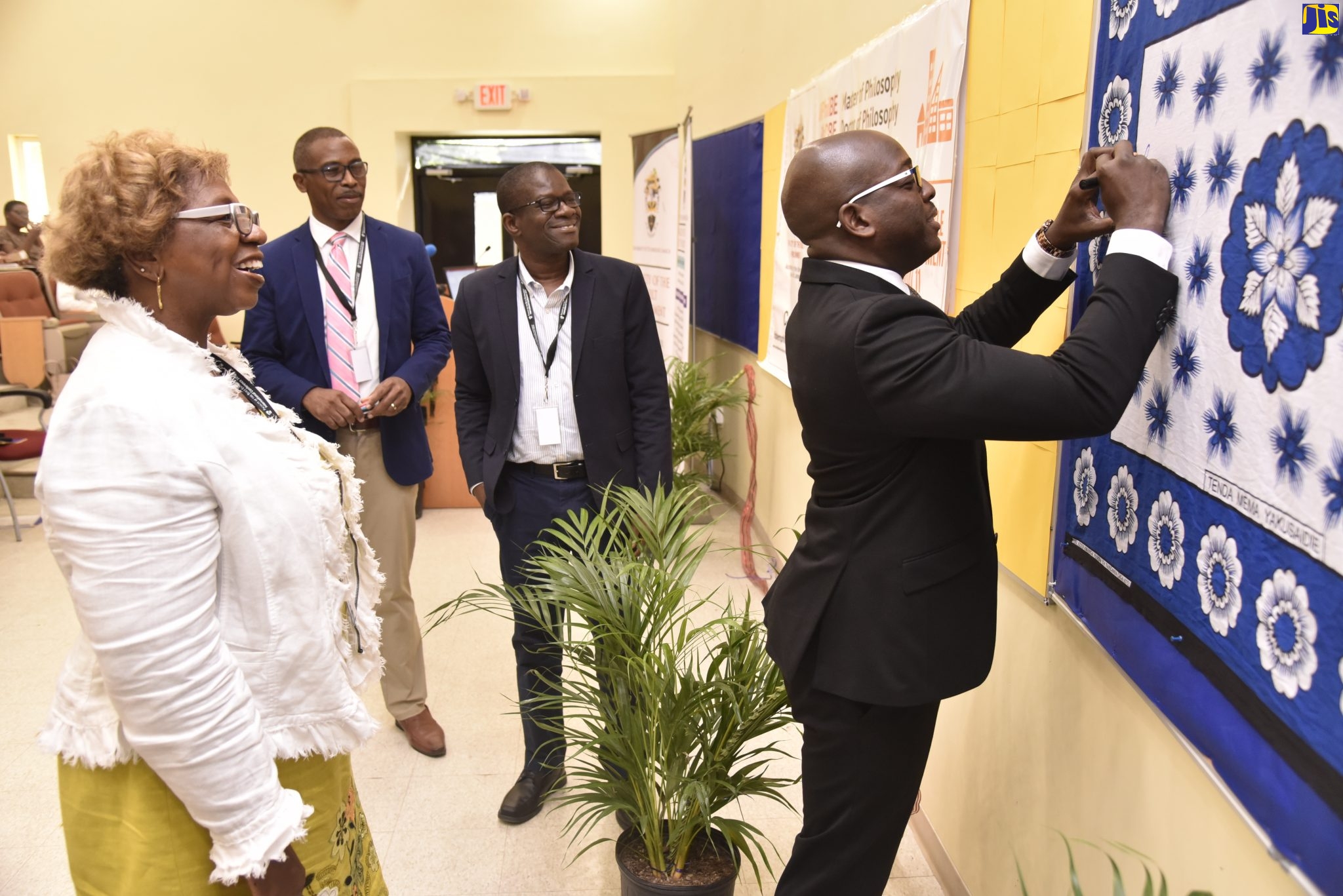 Minister without Portfolio in the Ministry of Economic Growth and Job Creation, Senator the Hon. Pearnel Charles Jr., signs artwork after delivering the keynote address at the University of Technology
