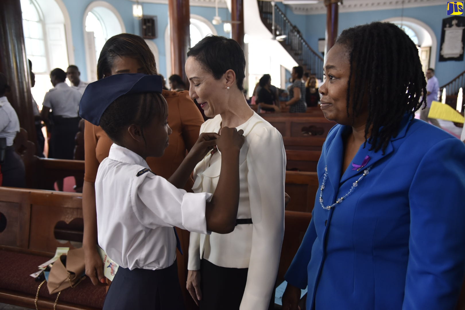 Minister of Foreign Affairs and Foreign Trade, Senator the Hon. Kamina Johnson Smith (centre), receives a commemorative pin from Girls Brigade member, Tanesha Whyte, during Sunday’s (November 17) church service at St. Andrew Scots Kirk United Church in downtown Kingston, in observance of World Day of Remembrance for Road Traffic Victims. Senator Johnson Smith read a message from Prime Minister, the Most Hon. Andrew Holness, who chairs the National Road Safety Council (NRSC). Sharing the moment (from left) are NRSC Executive Director, Paula Fletcher; and Pastor of St. Andrew Scots Kirk Church, Rev. Dr. Tamara Smith-Coleman.
