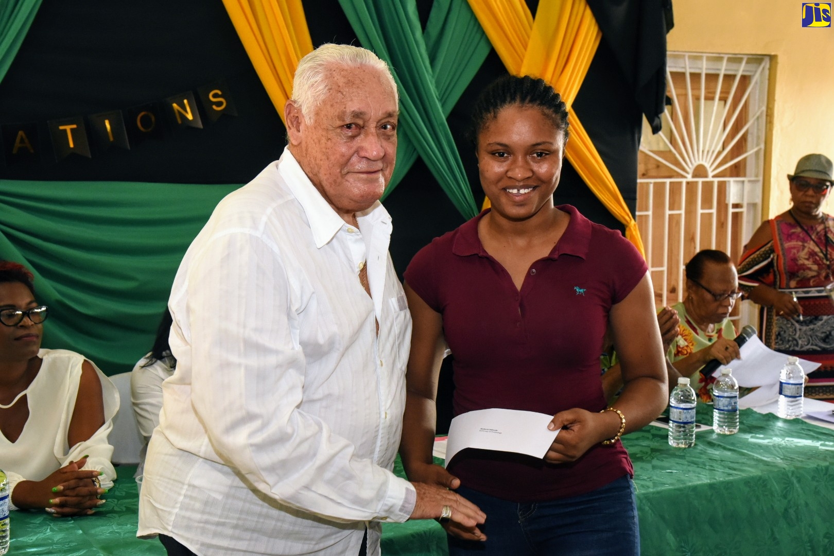 Minister without Portfolio in the Office of the Prime Minister and Member of Parliament for Central Manchester, Hon. Mike Henry, makes a presentation to University of Technology (UTech) student, Shakeria Johnson, at a function held on Sunday (November10), at the West Park Community Centre in Clarendon, during which tuition cheques totalling some $2.7 million, were awarded to 62 tertiary-level students. The occasion was also used to celebrate the recent conferment of the Order of Jamaica (OJ) on Minister Henry.