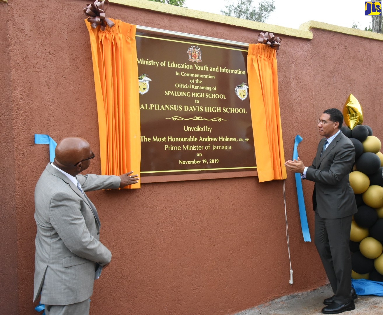 Prime Minister the Most Hon. Andrew Holness (right), applauds after unveiling the plaque commemorating the official renaming of the Spalding High School, Alphansus Davis High. At left is the former principal in whose honour the institution has been renamed. The ceremony was held at the school grounds in Clarendon on November 19.