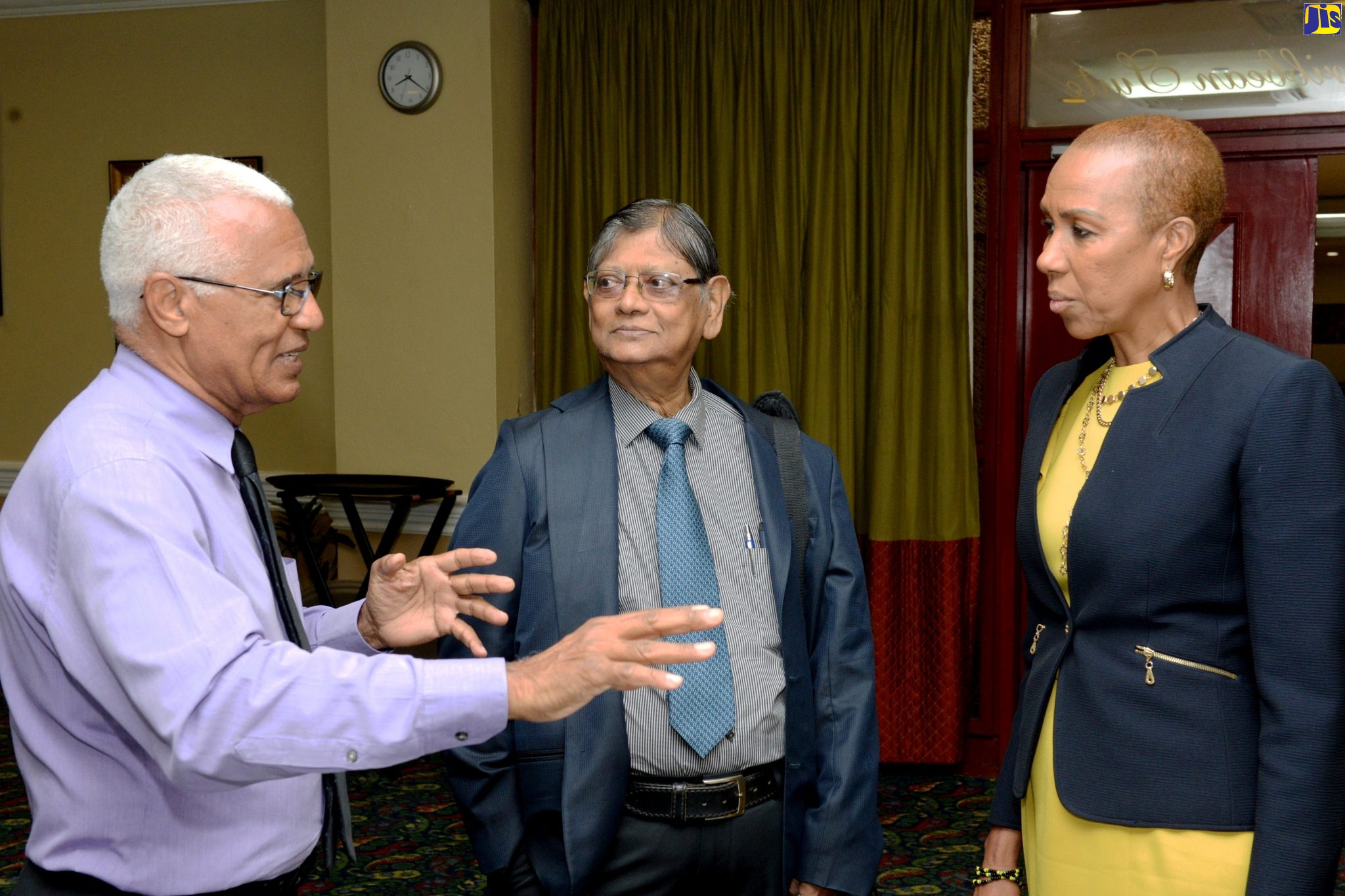 Minister of  Science, Energy and Technology, Hon. Fayval  Williams (right), listens as Chief Executive Officer of Pan Media, Knolly Moses (left), makes a point during Tuesday’s (November 26) energy retrofit workshop at The Knutsford Court Hotel in Kingston. Also listening is Project Principal Investigator of the Low Greenhouse Gas Emission: Promoting Energy Efficiency and Renewable Energy Building Jamaica Project, Professor Tara Dasgupta.