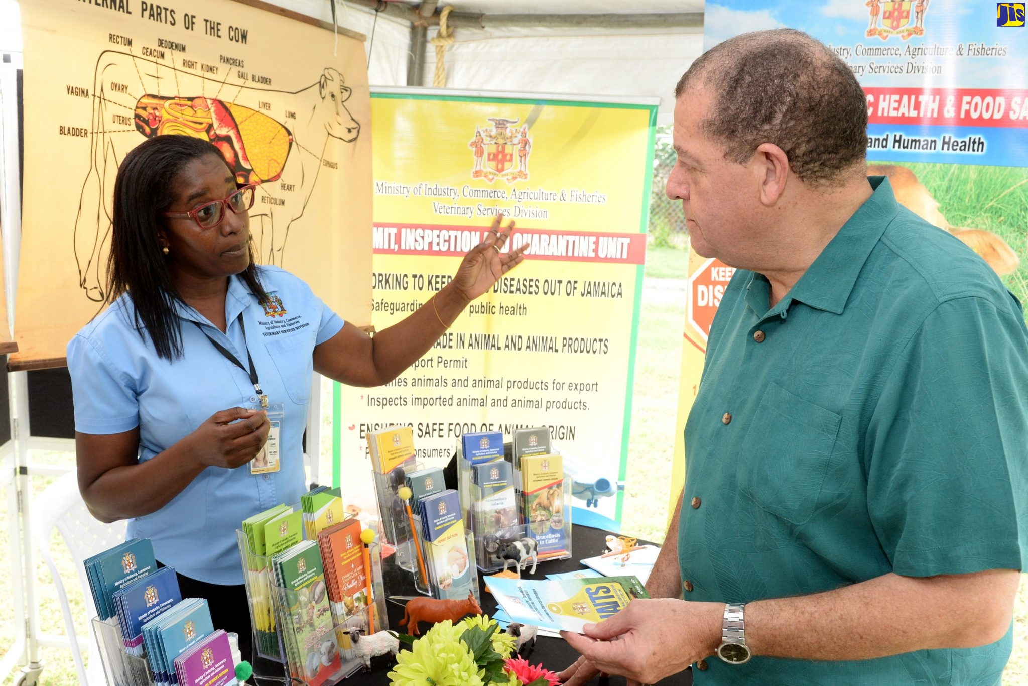 Minister of Industry, Commerce, Agriculture and Fisheries, Hon. Audley Shaw (right), listens to Animal Health Technician at the Ministry, Sharna Frater, at an Open Day staged by the Ministry’s Food Storage and Prevention of Infestation Division (FSPID), at Hope Gardens, in St. Andrew, on October 31.
