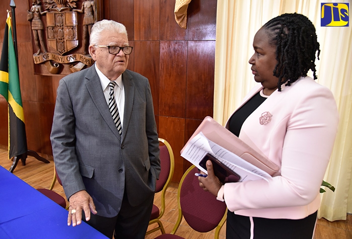 Minister without Portfolio with responsibility for Education, Youth and Information, Hon. Karl Samuda (left), conversing with Acting Permanent Secretary in the Ministry of Education, Youth and Information, Dr. Grace McLean, during today