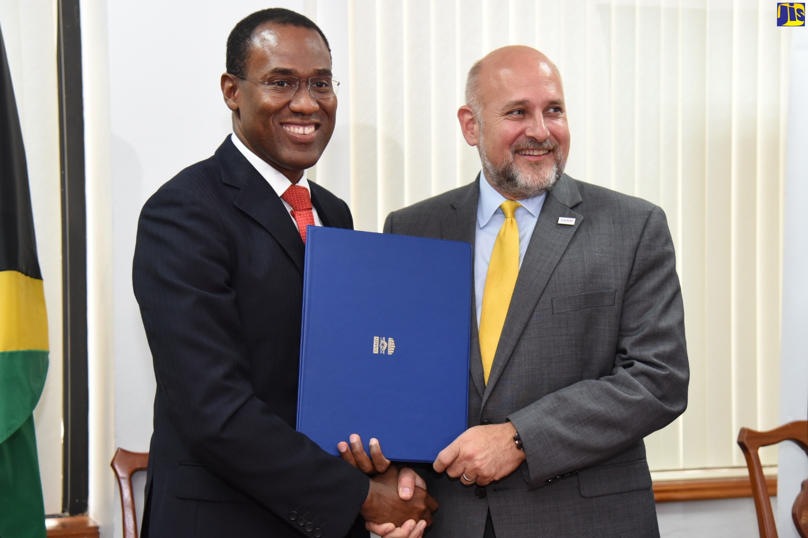 Minister of Finance and the Public Service, Dr. the Hon. Nigel Clarke (left),  and Assistant Administrator for Latin America and Caribbean Bureau, USAID/Washington, John Barsa, display  copy of the Memorandum of Understanding signed at the Ministry of Finance and the Public Service, on Thursday (October 31).