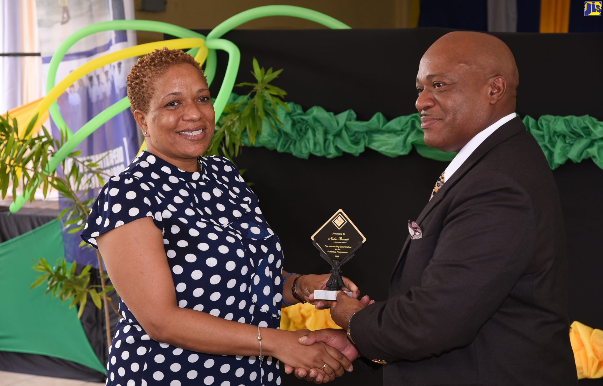 Commissioner of Corrections, Lieutenant Colonel (Retired) Gary Rowe, presents a plaque to Assistant Superintendent and English teacher, South Camp Juvenile Correctional and Remand Centre for Girls, Nadra Barnett. Occasion was the Department of Correctional Services (DCS) Juvenile Services Unit awards ceremony at Curphey Place, St. Andrew, on Tuesday (November 19).