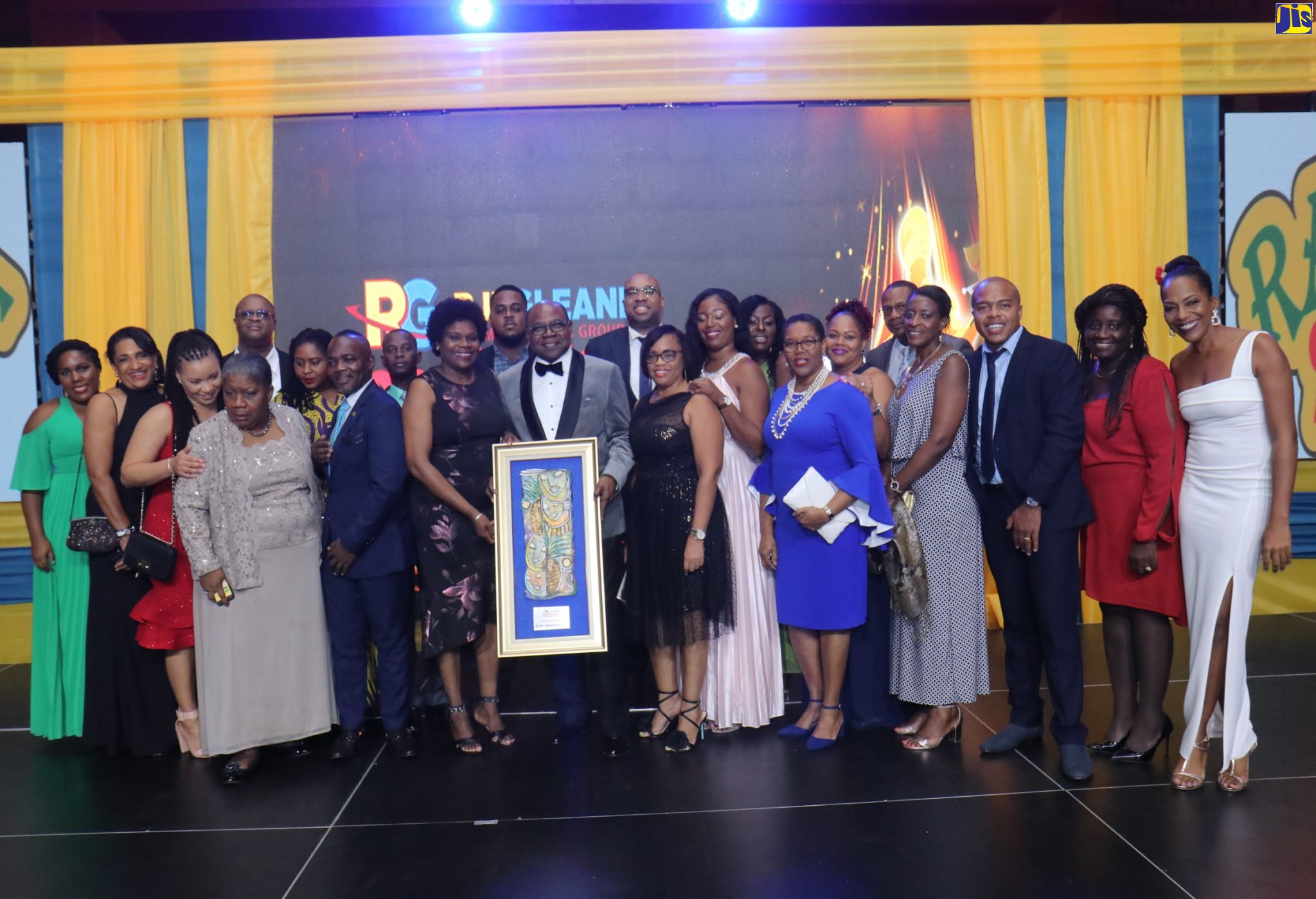 Tourism Minister, Hon. Edmund Bartlett (holding his Pioneer Award plaque), with Permanent Secretary in the Ministry, Jennifer Griffith (to his right), at the RJRGLEANER Hospitality Jamaica Awards ceremony on November 15, at the Montego Bay Convention Centre, St. James. Sharing the moment are team members from the Ministry of Tourism.