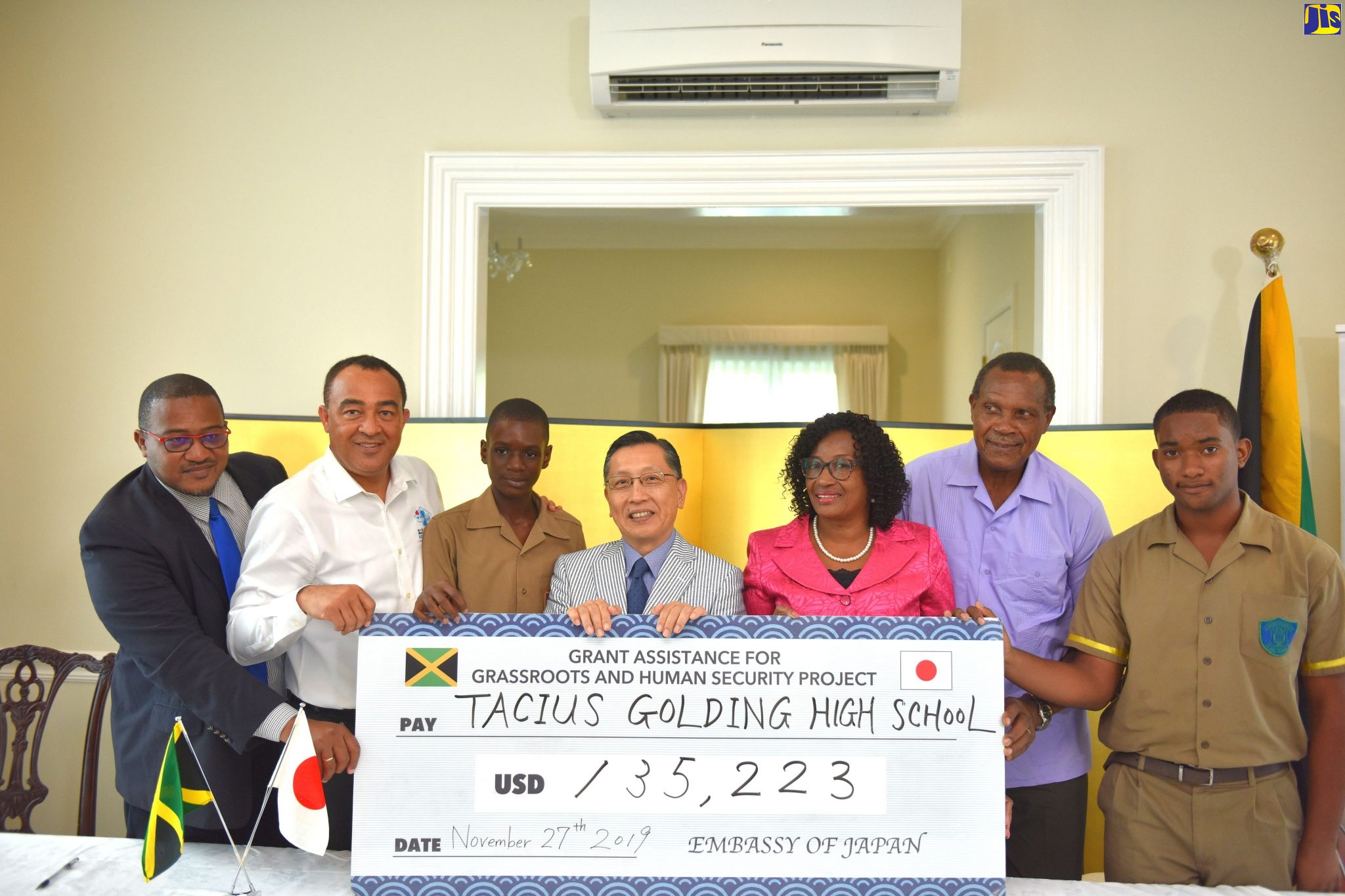 Minister of Health and Wellness, Dr. the Hon. Christopher Tufton (second left), along with (from left) Acting Director, Safety and Security in Schools Unit, Ministry of Education Youth and Information, Richard Troupe; Tacius Golding High School student, Christopher Wallace; Ambassador of Japan to Jamaica, His Excellency Hiromasa Yamazaki; School Principal, Lena Russell;  Board Chairman, Rev. Futtremann White; and student at the institution, Kevin Foster, display a symbolic cheque for grant funds totalling US$135,223 (J$15 million) to purchase two buses for the school. The grant-signing ceremony was held at the Japanese Ambassador’s residence in Kingston, on Wednesday (November 27). The institution is situated in West Central St. Catherine, for which Dr. Tufton is the Member of Parliament.
