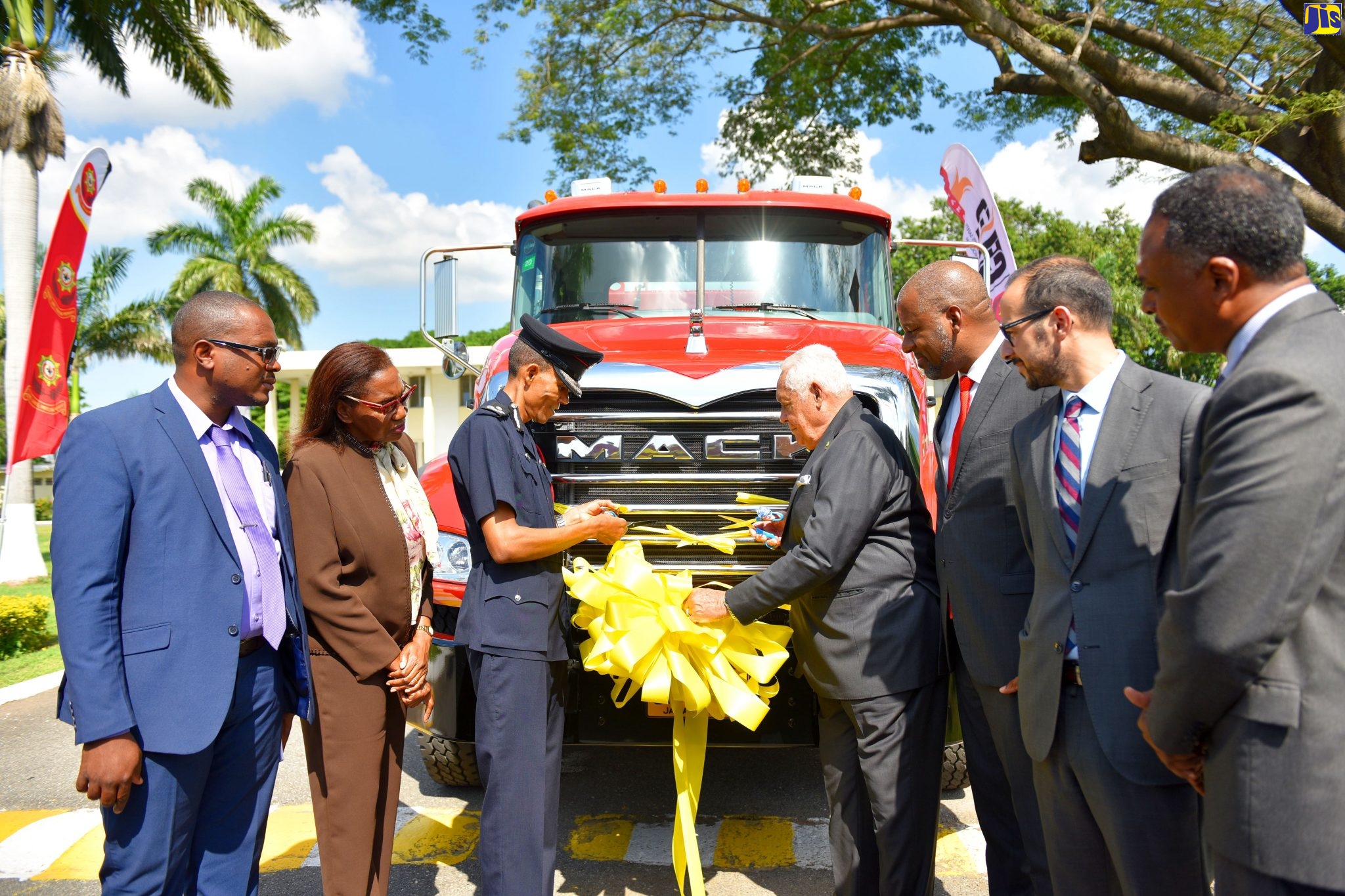 Minister without Portfolio in the Office of the Prime Minister, Hon. Mike Henry (centre), cuts the ribbon to symbolically hand over two water tender trucks to the Jamaica Fire Brigade (JFB). Looking on (from left) are: Councillor for the Yallahs Division, Stewart Lee; Custos of St. Thomas, Hon. Marcia Bennett; Commissioner, JFB, Stewart Beckford; Chairman, Jamaica Social Investment Fund (JSIF), Dr. Wayne Henry; World Bank Group Resident Representative for Jamaica and Guyana, Ozan Sevimli; and Managing Director, JSIF, Omar Sweeney. The handing over took place during a ceremony at Jamaica House on Friday (Nov. 22). The trucks were acquired under the Jamaica Disaster Vulnerability Reduction Project (JDVRP), which is being implemented by JSIF through funding from the World Bank.